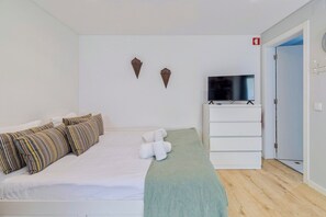 Ein Hotelzimmer mit Bett, Fernseher, Kleiderschrank und Tür.
