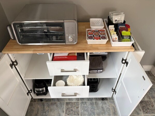 A kitchen counter with a toaster, a coffee machine, and various food items.