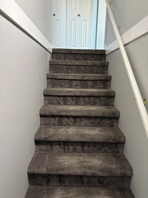 A staircase with a handrail and a door at the top.