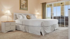 Une chambre à coucher avec un lit, deux tables de chevet, une commode, une fenêtre avec des rideaux et un tableau encadré au mur.