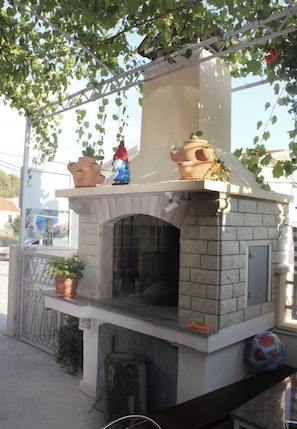 A brick-built outdoor oven with terracotta pots and a gnome figurine on top. - A6 - Spacious apt w pool, terrace and sea view (Dugi Rat)