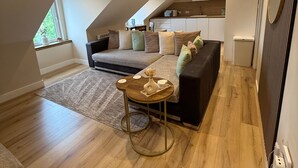 Un loft modern amb un llit d'altitud, un sofà, una taula petita i una zona de cuina.