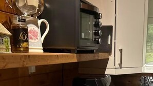 A compact kitchen with a microwave, toaster, and coffee maker on the countertop. - Gortin Glen Forest Cabin, Sleeps 7 with Parking (Omagh)