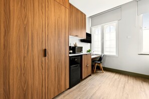 Eine moderne Küche mit Holzschränken, einer Mikrowelle und einem Geschirrspüler.