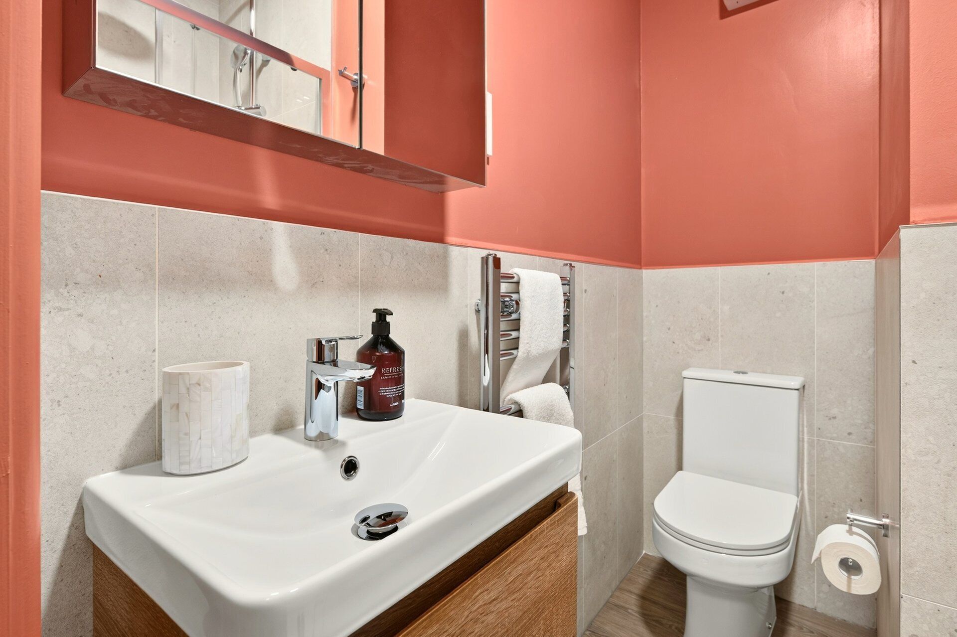 Een badkamer met een wit wastafel, toilet en handdoekhouder.
