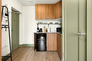 Eine kompakte Küche mit Holzausstattung, einem Geschirrspüler und einer Kaffeemaschine.
