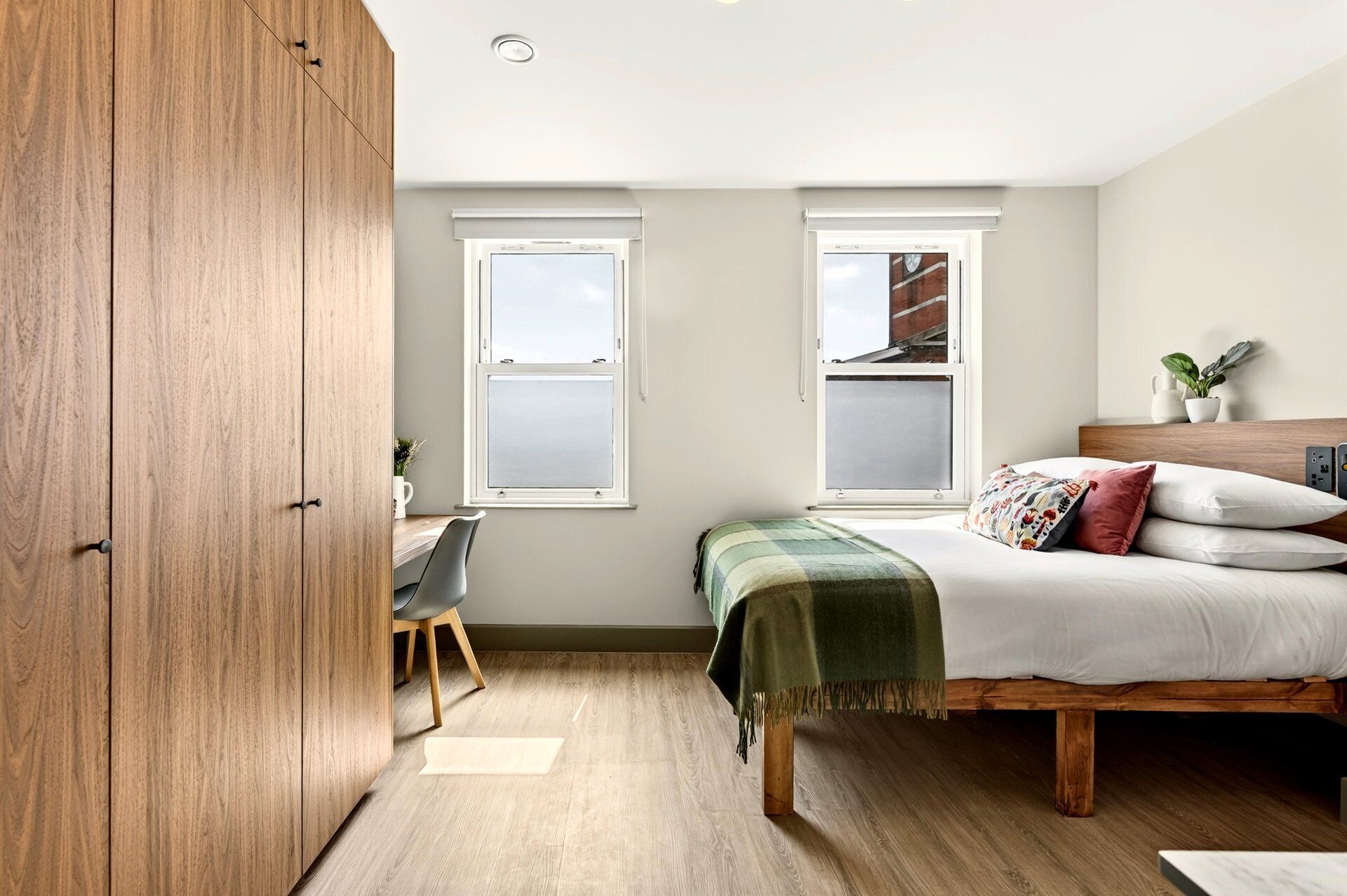 Un dormitorio con cama, escritorio y armario.