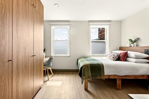 Ein Schlafzimmer mit einem Bett, einem Schreibtisch und einem Kleiderschrank.