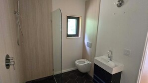 A bathroom with a shower, toilet, and sink.
