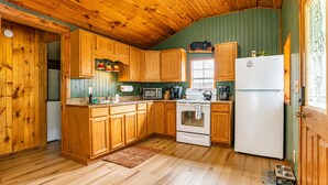 A kitchen with wooden cabinets, a refrigerator, a stove, and a microwave. - Onyx at Nada - Your Escape to Nada Tunnel (Stanton)