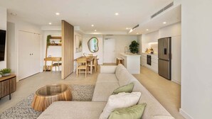 Een modern appartement met een woongedeelte, een eethoek en een keuken.