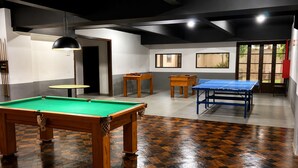 Une salle de billard équipée d’une table de billard, d’une table de ping-pong et d’un porte-billes.