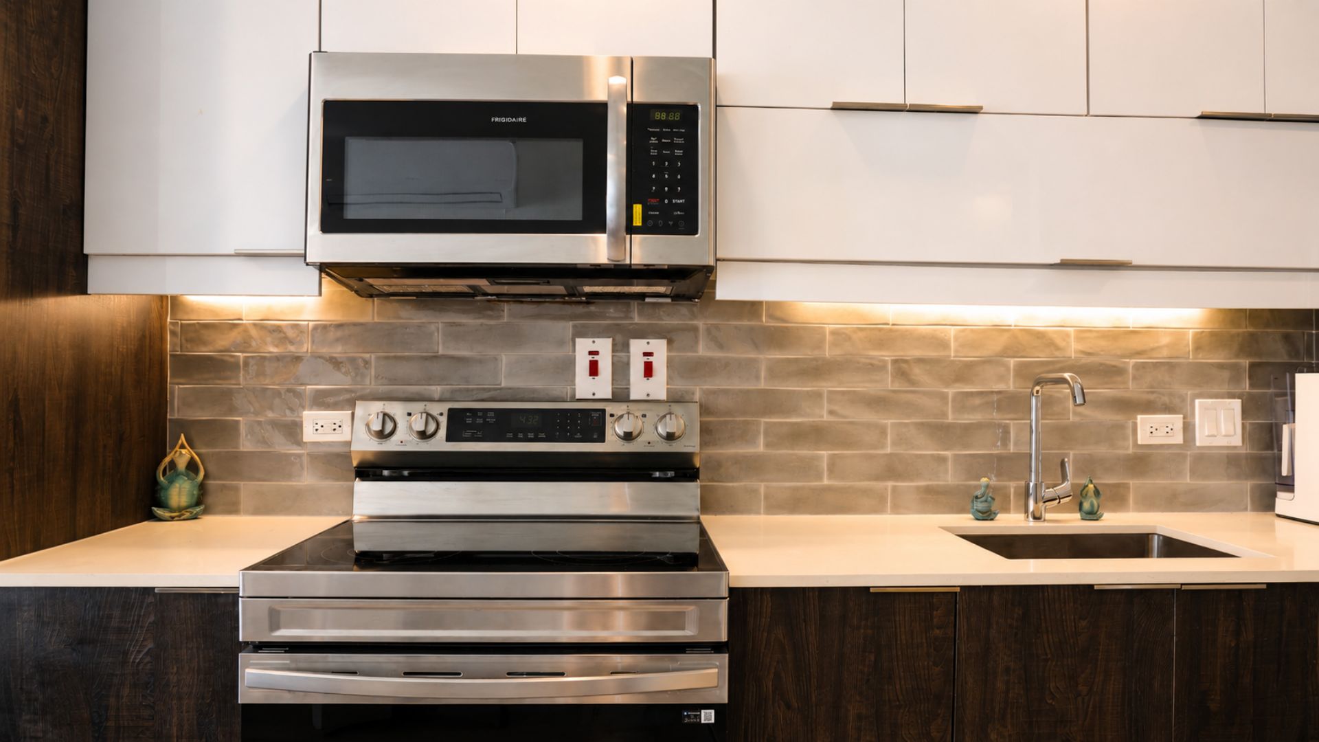 A kitchen with a built-in microwave, double oven, and a stainless steel range hood.