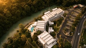 An aerial view of a hotel complex with multiple buildings, a swimming pool, and a river. - Bessa Beachfront Ocean Suite | 2BR | Oracabessa ➠ U71 (Oracabessa)