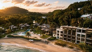 Ein Resort mit Pool, Strand und üppiger Bepflanzung.