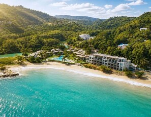 Ein Resort mit Strandzugang, Pool und üppiger Bepflanzung.