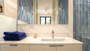 A bathroom with a white sink, a mirror, and a window. - Bessa Ocean Suite Loft | 3BR + Private Roof Terrace ➠ U83 (Oracabessa)