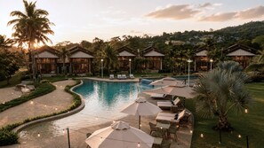 Ein Resort mit Schwimmbad, Liegestühlen und Sitzbereichen im Freien.