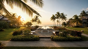 A resort with a pool, palm trees, and a view of the ocean at sunset. - Bessa | Riverfront Studio | River, Sea & Pool ➠ U20 (Oracabessa)