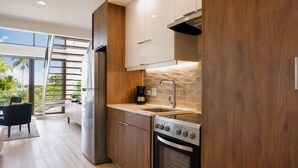 A modern kitchen with a built-in stove, a coffee maker, and a view of the outdoors. - Bessa | Riverfront 2BR Loft, Private Roof Terrace ➠ U11 (Oracabessa)