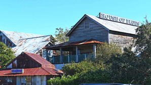 Un edificio rústico con un letrero que dice "HOUSE OF BLUES" y una estructura más pequeña con la leyenda "GEAR SHOP" al frente.