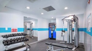 Un gimnasio con racks de pesas, bancos y máquinas de ejercicio.