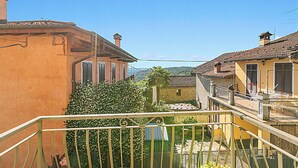 Ein Wohngebiet mit traditioneller Architektur, einem Balkon mit Metallgeländer und blauem Himmel.