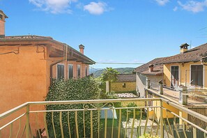 A residential area with traditional architecture, a balcony with a metal railing, and a clear blue sky. - Quadrifoglio Stresa Hill with A/C and Sunny Balcony, Stresa, Italy (Stresa)