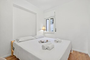 A white room with a bed, a window, and a lamp. - Quadrifoglio Stresa Hill with A/C and Sunny Balcony, Stresa, Italy (Stresa)