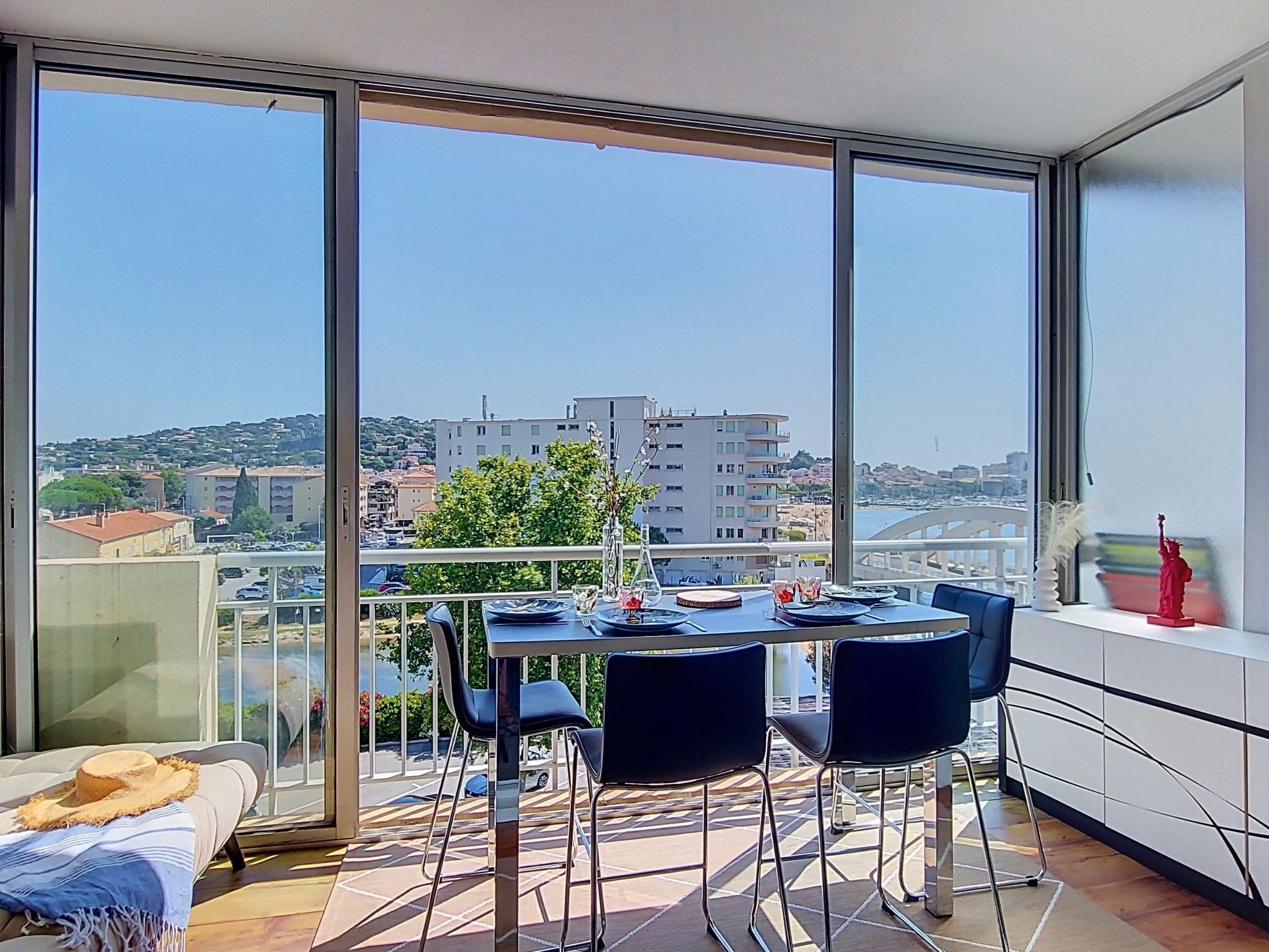 Een balkon met een eettafel, stoelen en uitzicht op de stad.