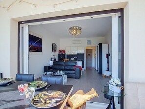 A modern living room with a sofa, dining table, and a chandelier. - Bel Horizon 2 by Interhome (Sainte Maxime)