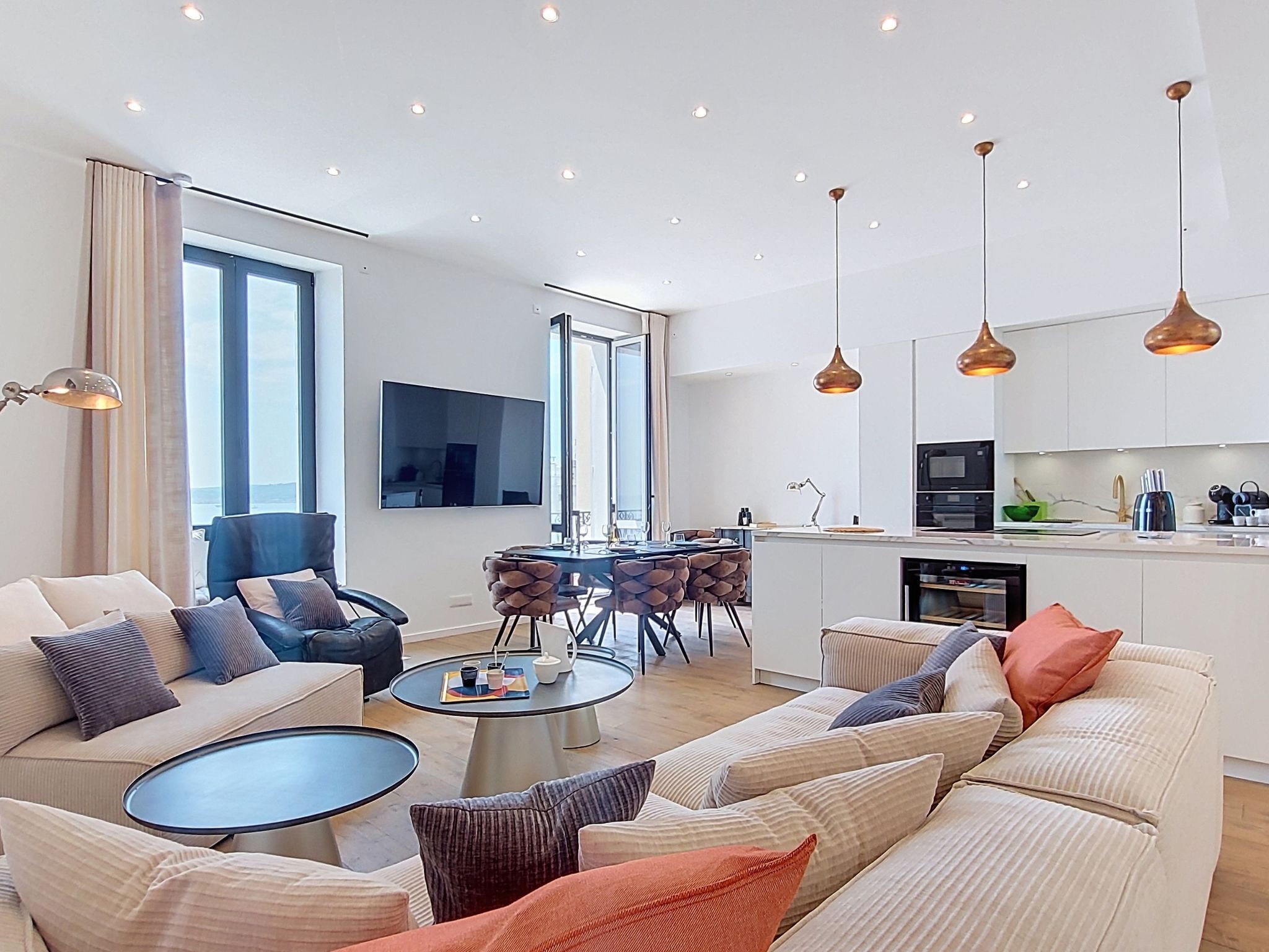 A modern living room with a sofa, coffee table, and dining area.