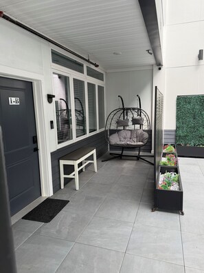 Ein modernes Interieur mit einer Bank, einem Hängekorbstuhl und einem Pflanzgefäß mit Pflanzen.