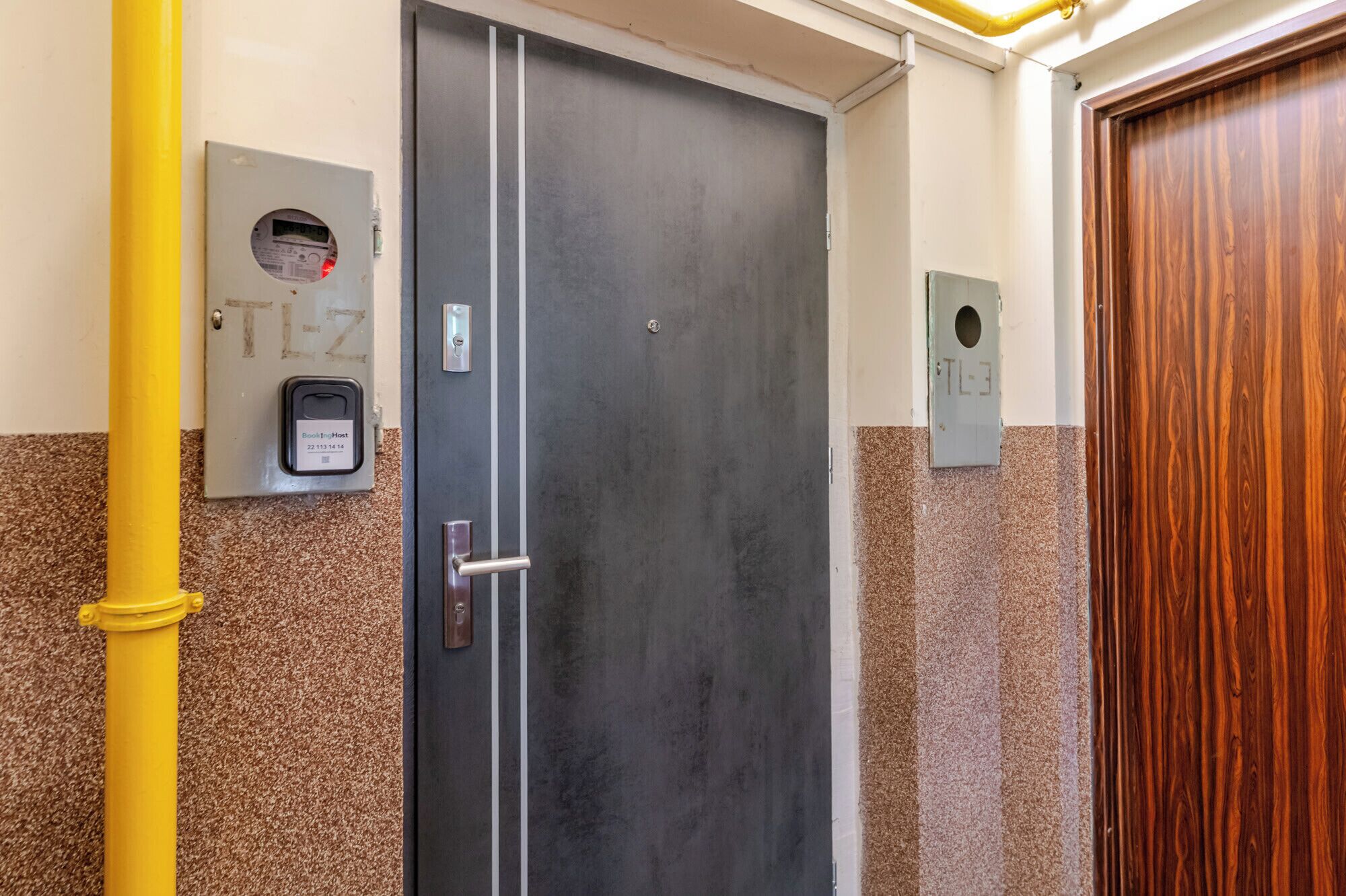 A door with a handle, a keypad, and a sign with 'Book-In-Host' and a number.
