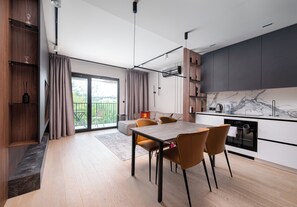 Eine moderne Küche mit Essbereich, einem Einbauofen und einem großen Fenster.