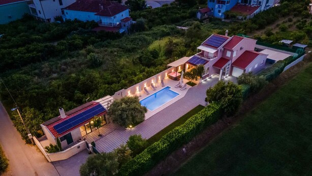 Ein großzügiges Haus mit Swimmingpool, Solaranlage und einem gepflegten Garten.