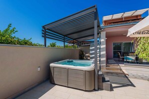 A hot tub with a pergola structure, a poolside area, and a Coca-Cola branded umbrella. - Villa with swimming pool and hot tub (Metković)