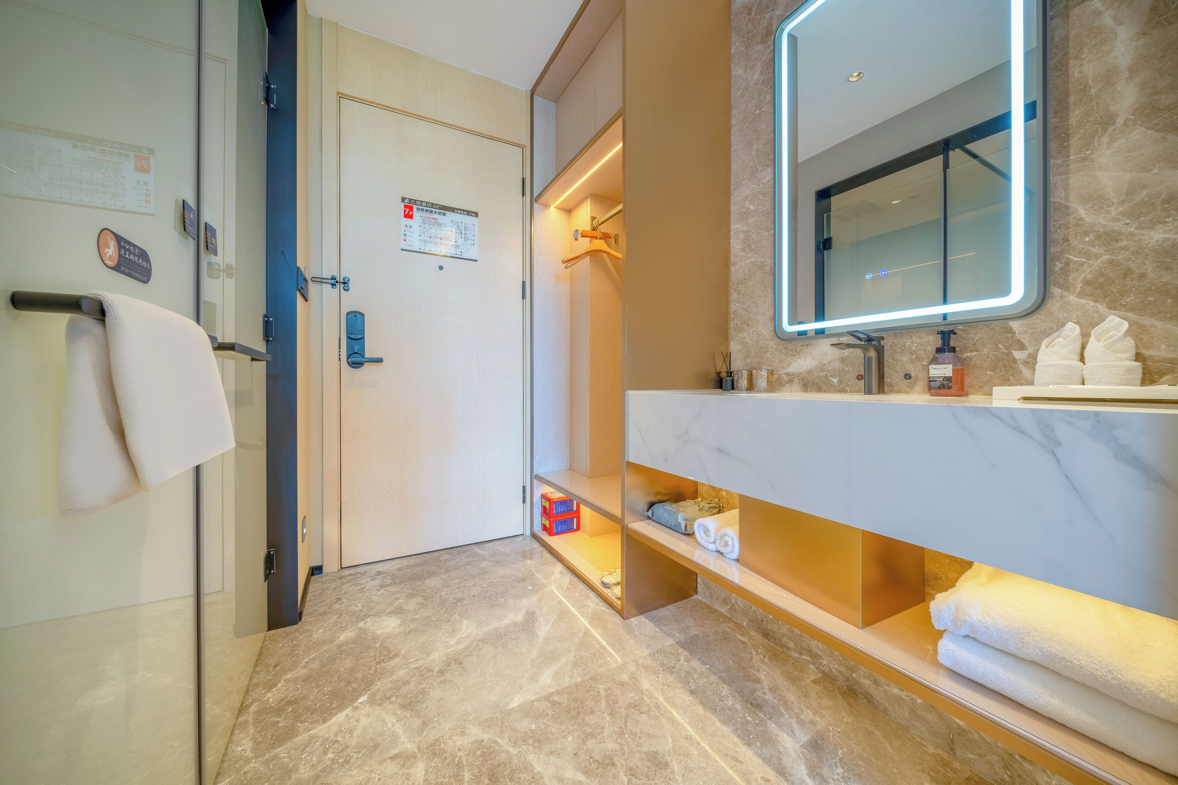 A modern bathroom with a marble floor, a large mirror, and a towel rack.