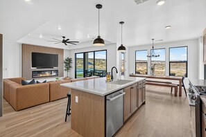 A modern kitchen with a central island, built-in appliances, and large windows offering a view of the desert.