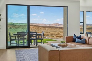 A living room with a sliding glass door leading to a patio, a sofa, a coffee table, and a small plant.