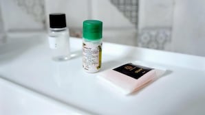 A bathroom with a white sink, a bottle of liquid soap, and a bar of soap on the counter.