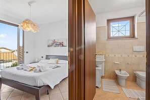 Una camera da letto con un letto, un bagno con bidet e vista all'esterno.