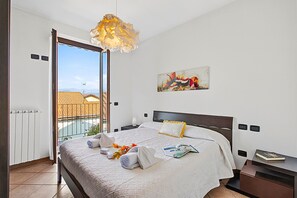 Camera d'albergo con un letto, un comodino, una lampada da lettura, un quadro e vista esterna.