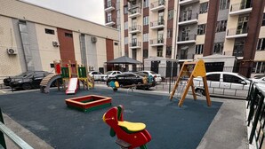 Un parque infantil con tobogán, columpios y sube y baja.