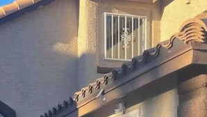 Ein zweistöckiges Gebäude mit einer Garagentür, einem kleinen Fenster und einer Tür.