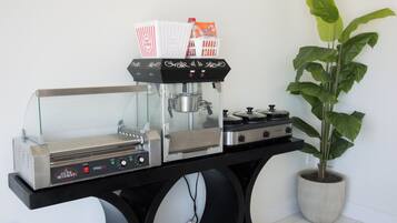 Une cuisine équipée d’une machine à café, agrémentée d’une plante en pot et dotée d’un sol carrelé.