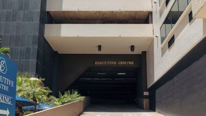 Ein Gebäudeeingang mit einem Schild für das Executive Centre und einem Hinweisschild für den Executive Centre Parkplatz.