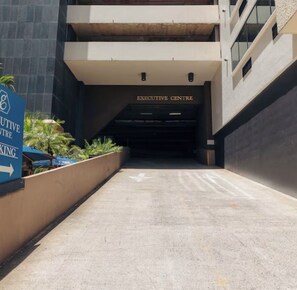 A building entrance with a sign for the Executive Centre and a directional sign for Executive Centre Parking. - Chic studio condo with Free Parking & AC in vibrant Downtown Honolulu (Honolulu)