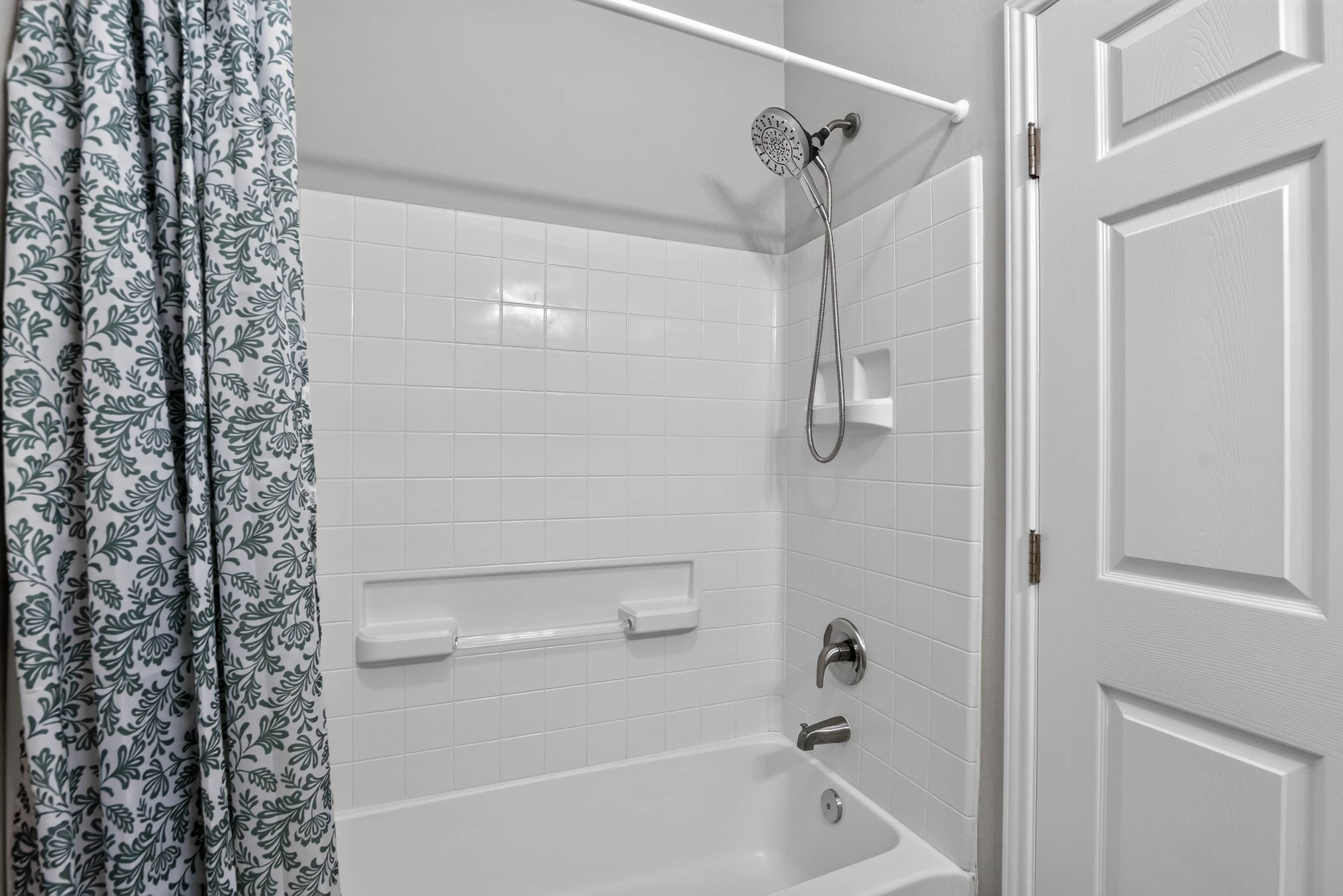 Une salle de bain avec une douche, une baignoire et des toilettes.