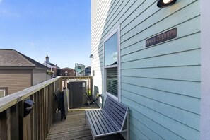 Ein Gebäude mit einem Schild, auf dem 'PORCH THERAPY' steht, und einer Holzterrasse, die zu einer Bank führt.